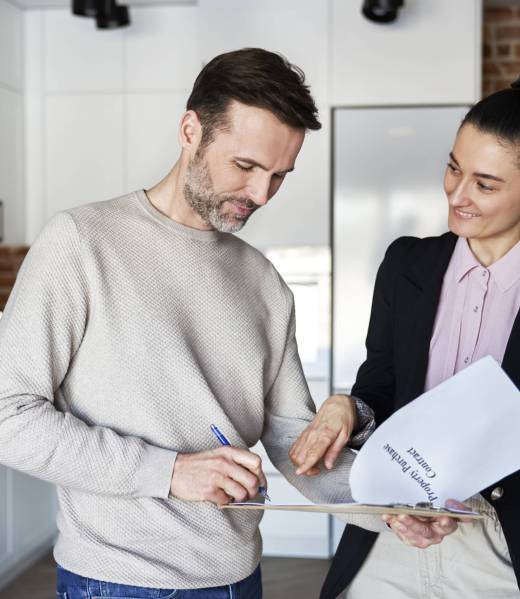 Man with real estate agent signing contract of new apartment